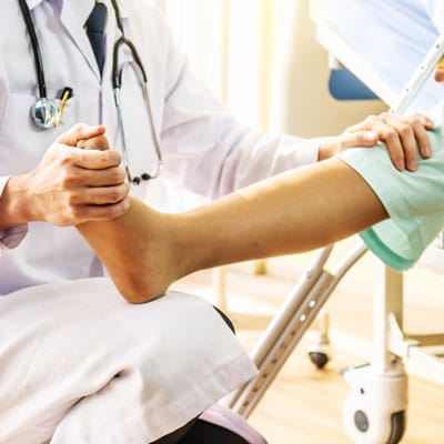 Doctor And Patient Doctor Examining Of The Leg From The Knee And Ankle And Training Broken Leg Patient In Hospital Physical Therapy Concept