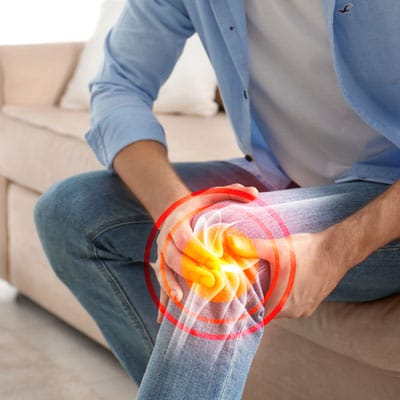 Man Suffering From Knee Pain At Home, Closeup